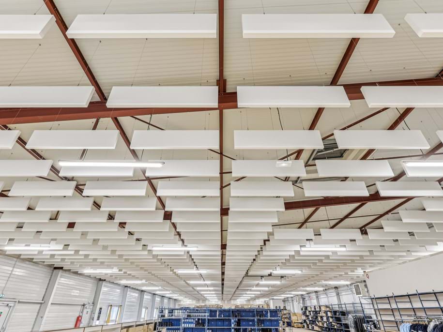 Photo en vue plongeante de nombreuses baffles acoustiques suspendues au plafond organisées en plusieurs rangées.