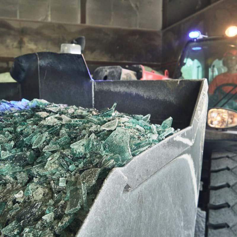 Kierrätyslasimurskaa kauhakuormaajan kauhassa