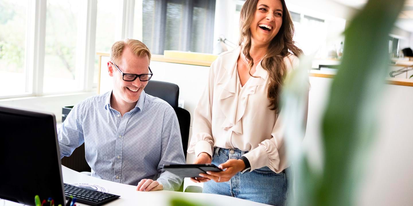 Collaboratori di Ecophon in sala conferenze che parlano e ridono