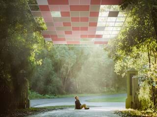 Hombre sentado en el suelo y techo acústico en el cielo mirando fijamente