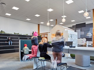 Pupils studying in an open-learning area with suspended acoustic ceiling.