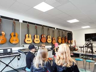 Pupils in music room with suspended acoustic ceiling.