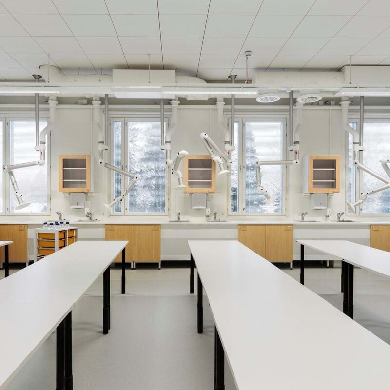 Moderni mokslo laboratorija su ilgais baltais stalais, medinėmis spintelėmis, vėdinimo įranga. Keli langai natūraliai apšviečia erdvę. Prie lubų sumontuotas apvalus sieninis laikrodis.