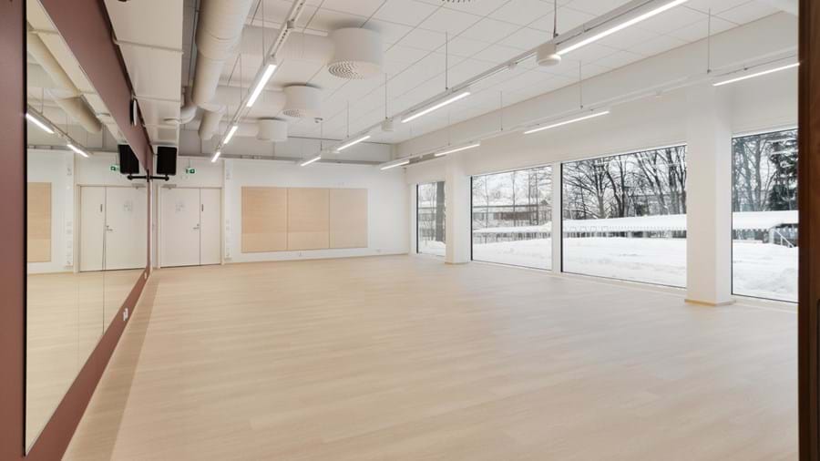 Tuščia, šiuolaikiška šokių studija su šviesaus medžio grindimis, dideliais veidrodžiais vienoje sienoje ir langais priešingoje pusėje, praleidžiančiais natūralią šviesą. Už langų matosi sniegas. Lubose yra atviri ortakiai ir šviestuvai.