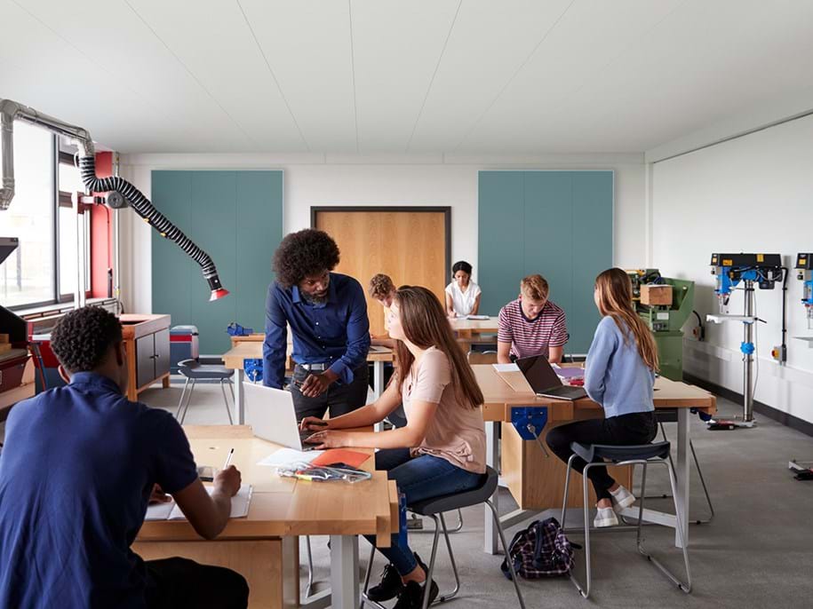 Insegnante e studenti in classe con pannelli acustici sulla parete