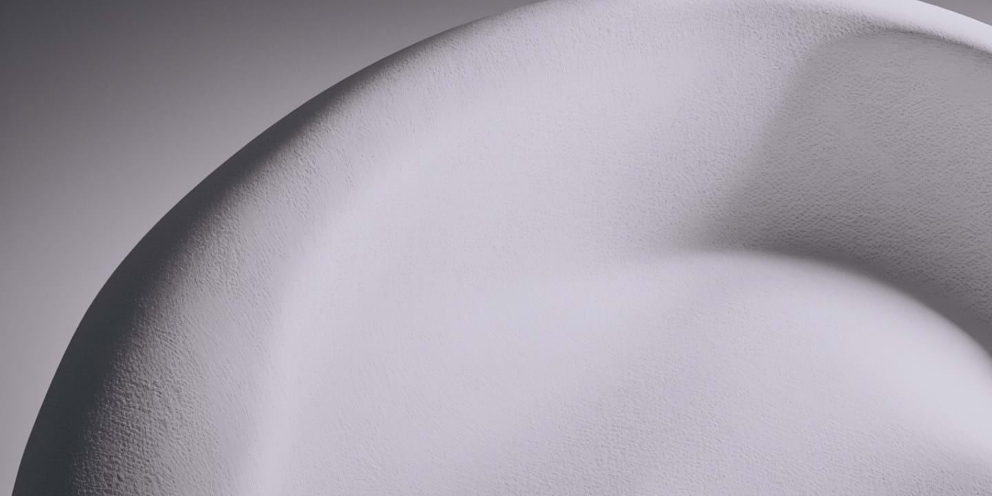 Close-up view of a white, textured surface with soft undulating curves and subtle shadows, giving the impression of a smooth, sculpted object.