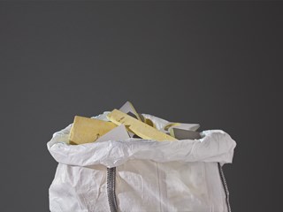 Close-up of a white plastic bag filled with used acoustic glasswool panels
