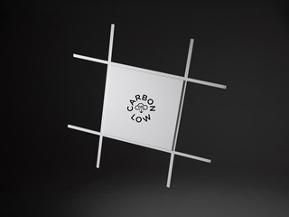 A white acoustic panel in a grid system on a black background. A logotype saying "Carbon low" is visible on the panel.